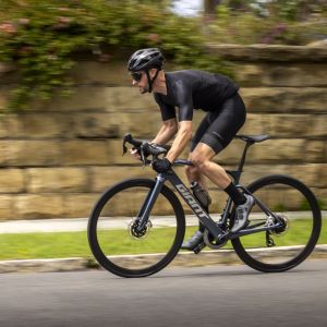 Un cycliste sprinte hors de la selle sur un Giant Defy E+ Elite.