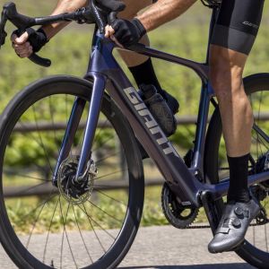 Close up side view of Giant Defy E+ Elite as cyclist goes by.